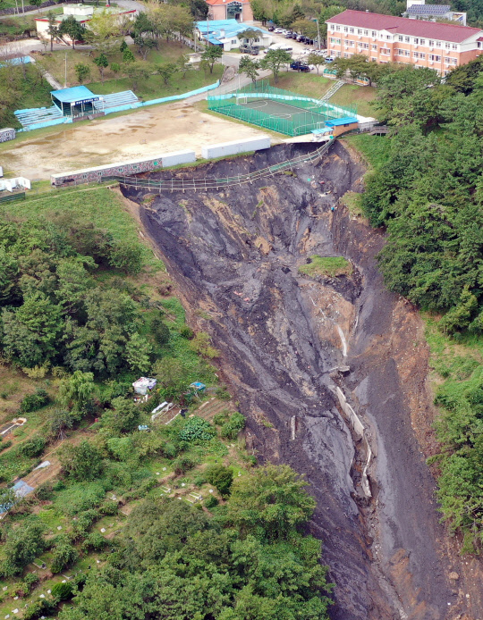 순식간에 와르르  태풍 미탁이 한반도를 관통한 3일 부산 사하구 산사태 사고 현장. 예비군 연병장에서 토사가 흘러내린 모습이다. 사고 순간 토사가 식당, 공장 건물 3곳을 덮쳐 주민 4명이 매몰된 것으로 추정된다.    연합뉴스